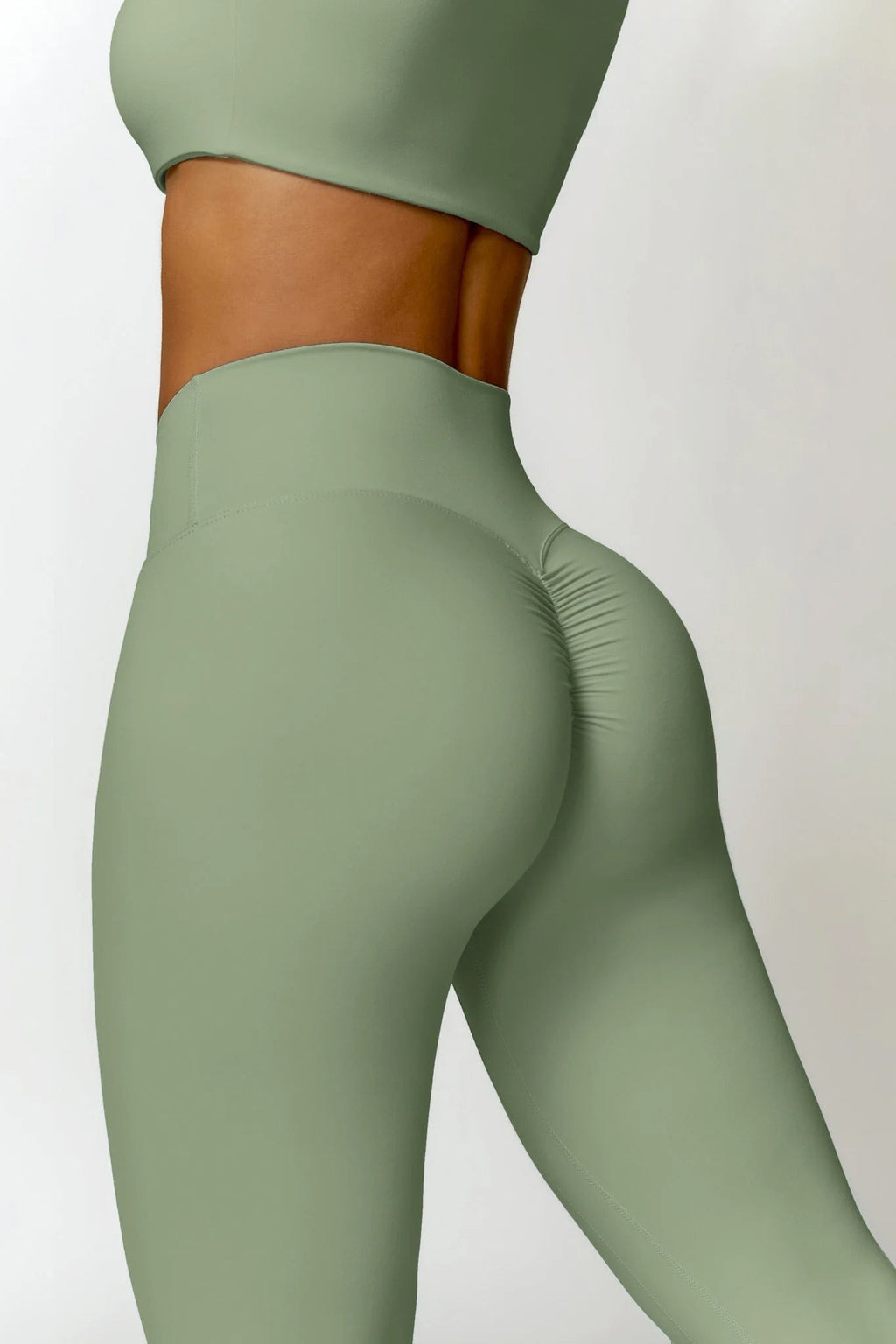 Green leggings worn by a person on a white background