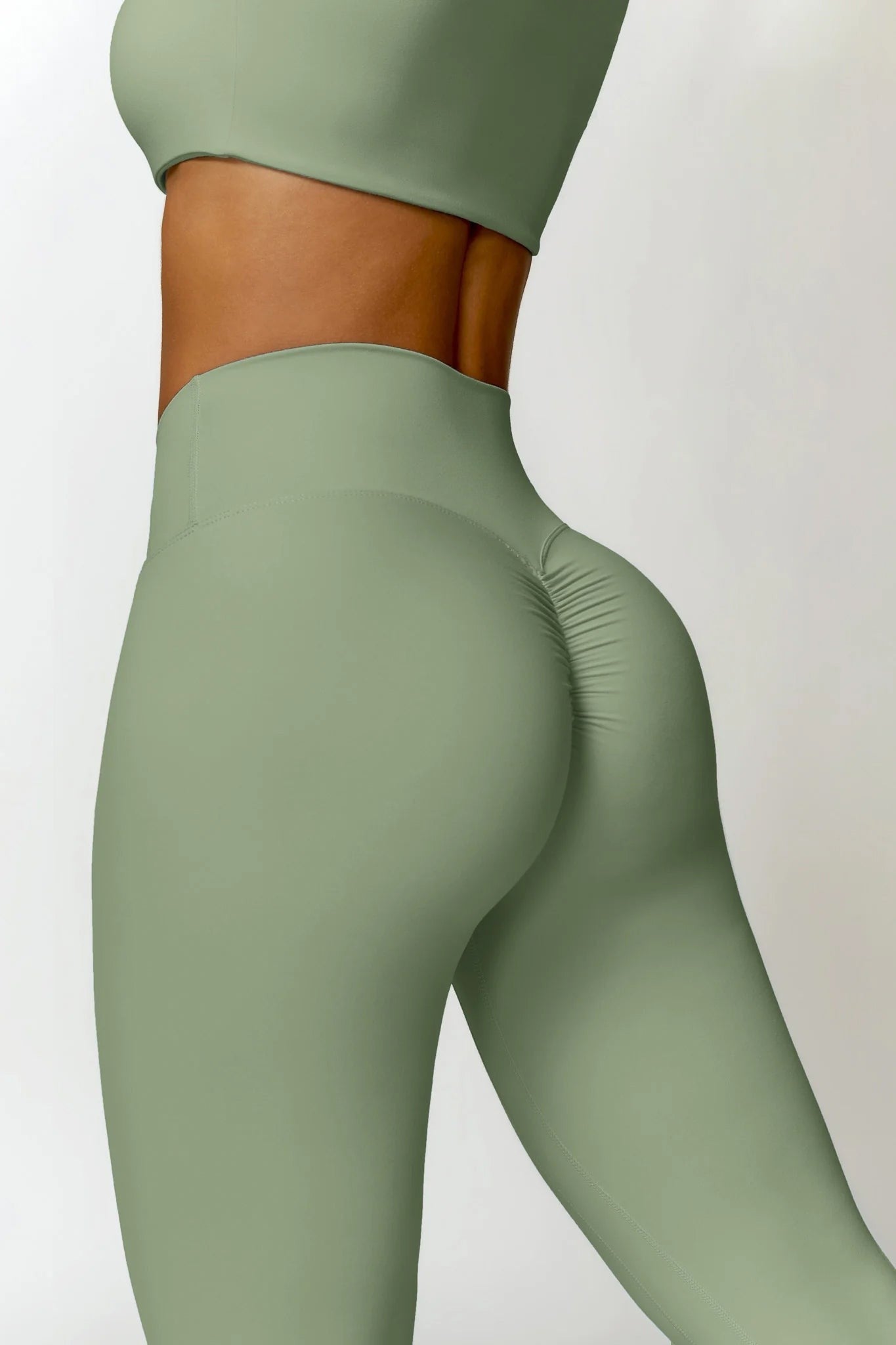 Green leggings worn by a person on a white background