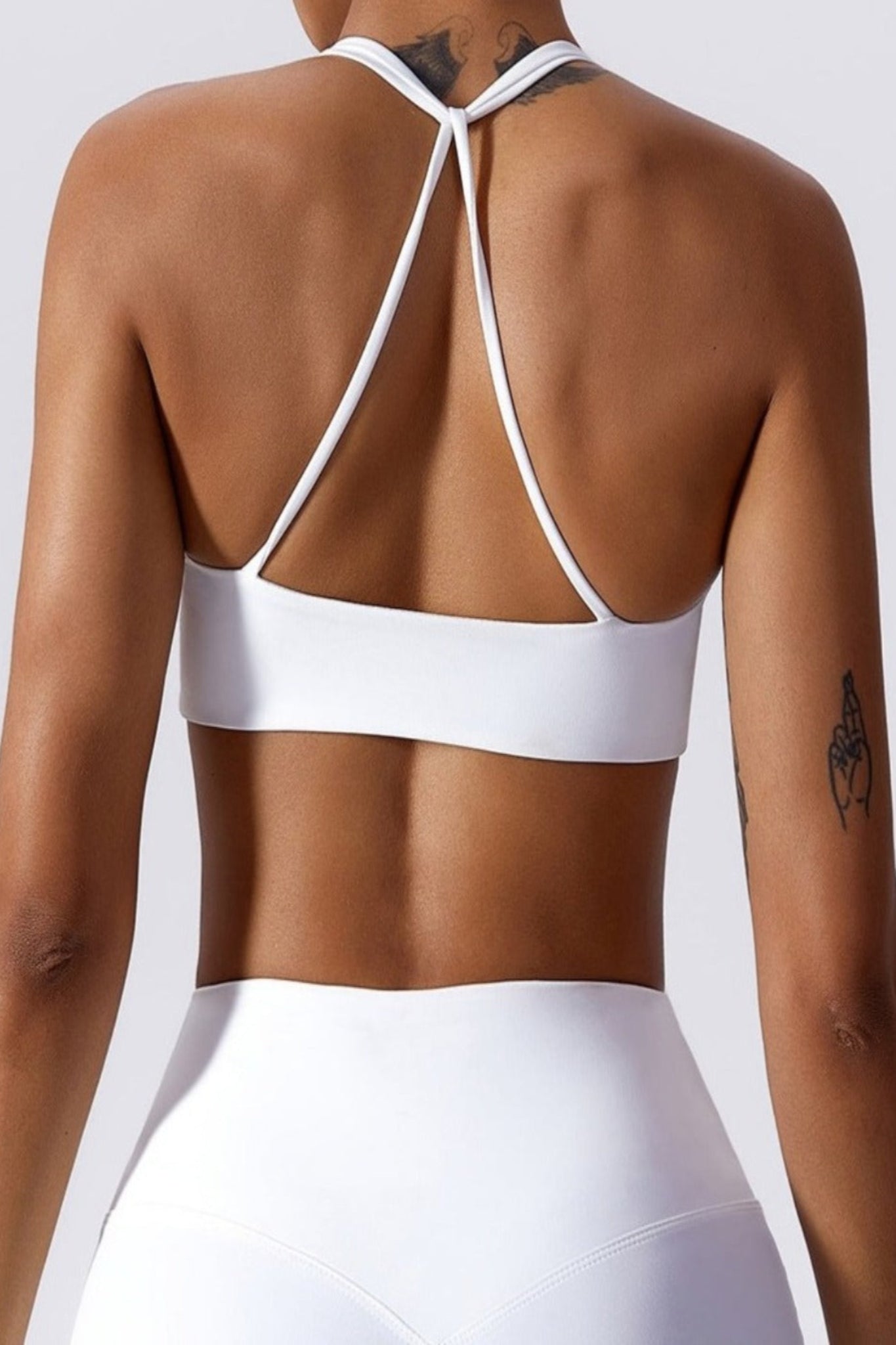White sports bra worn by a person on a white background