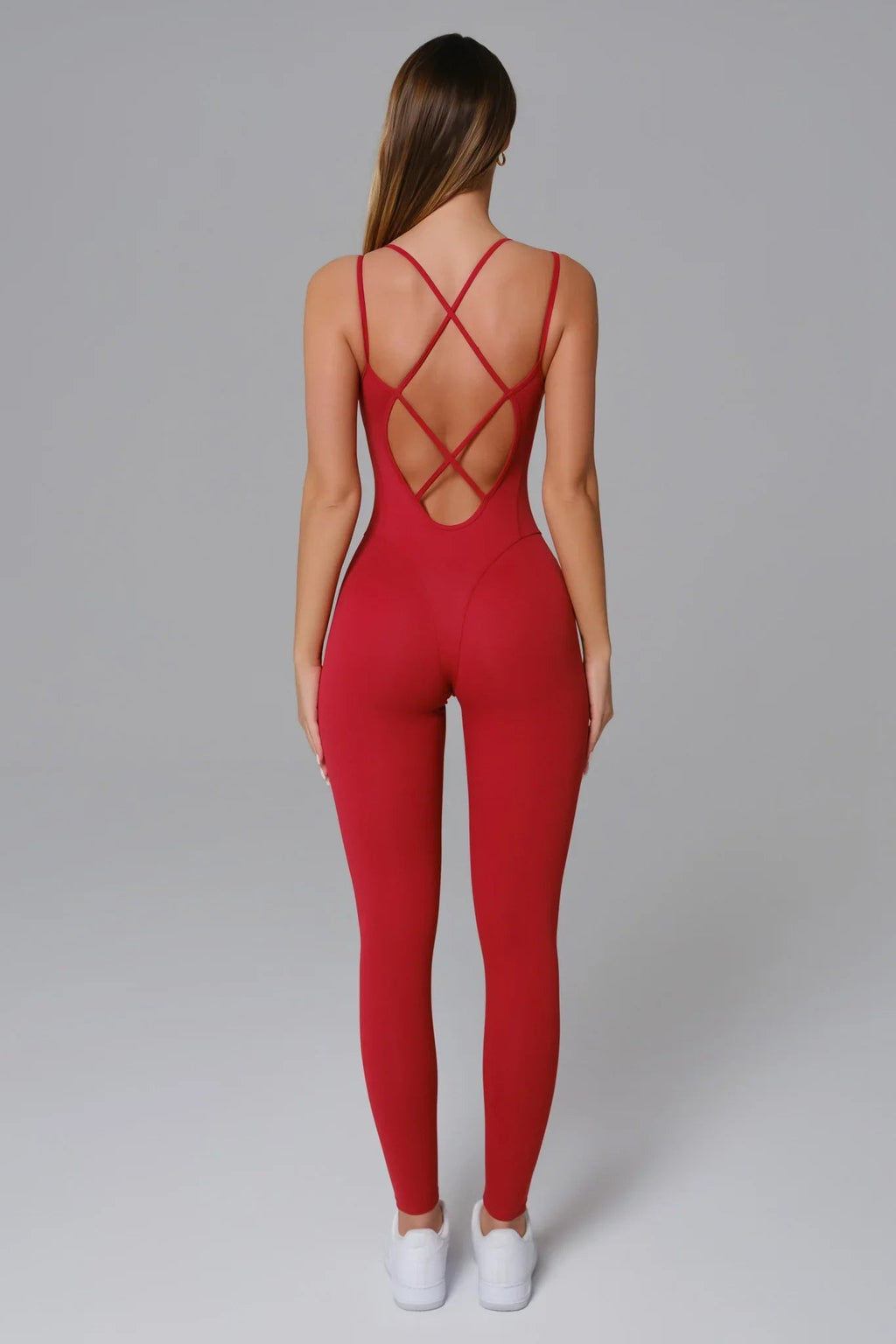 Red jumpsuit with criss-cross back design on a gray background