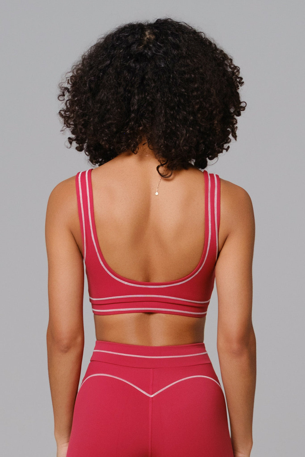 Woman wearing a Cherry red sports bra and leggings set 