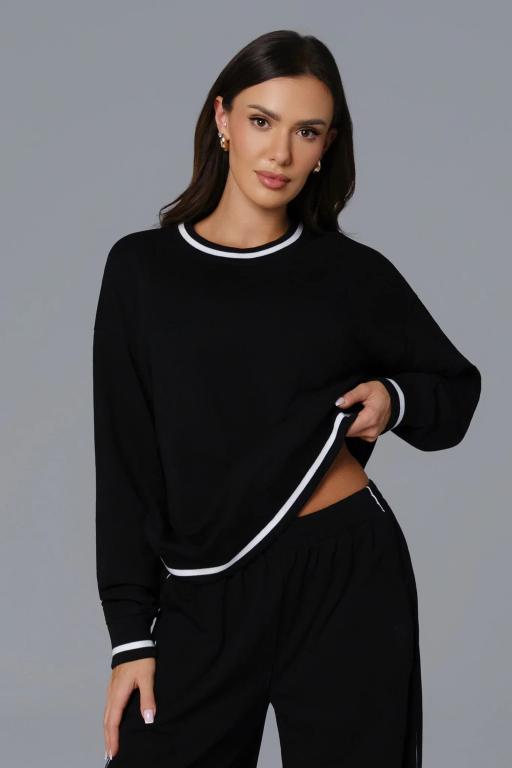 Woman wearing a black athleisure casual outfit with white trim 