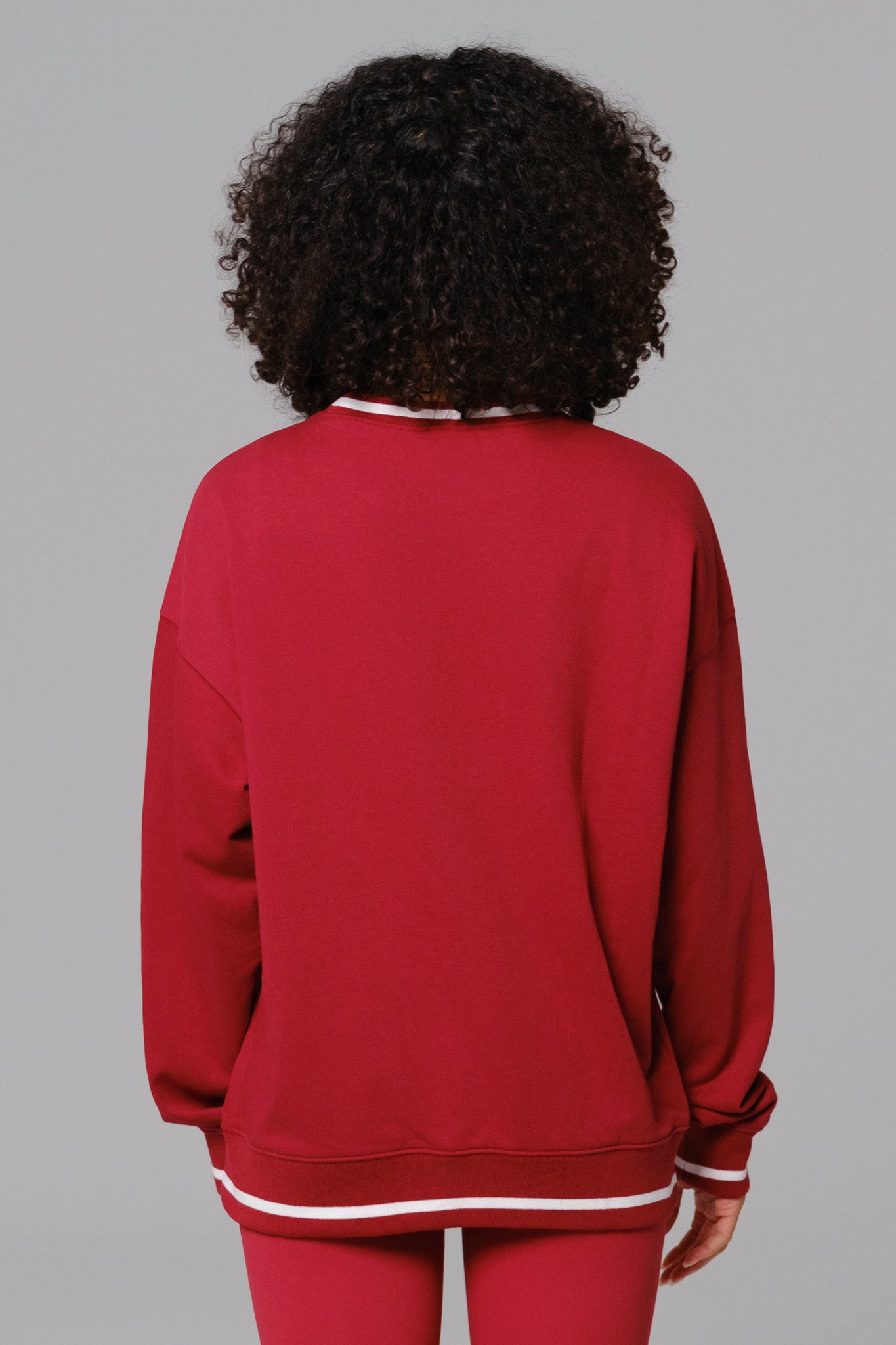 Woman wearing a red sweatshirt and leggings set
