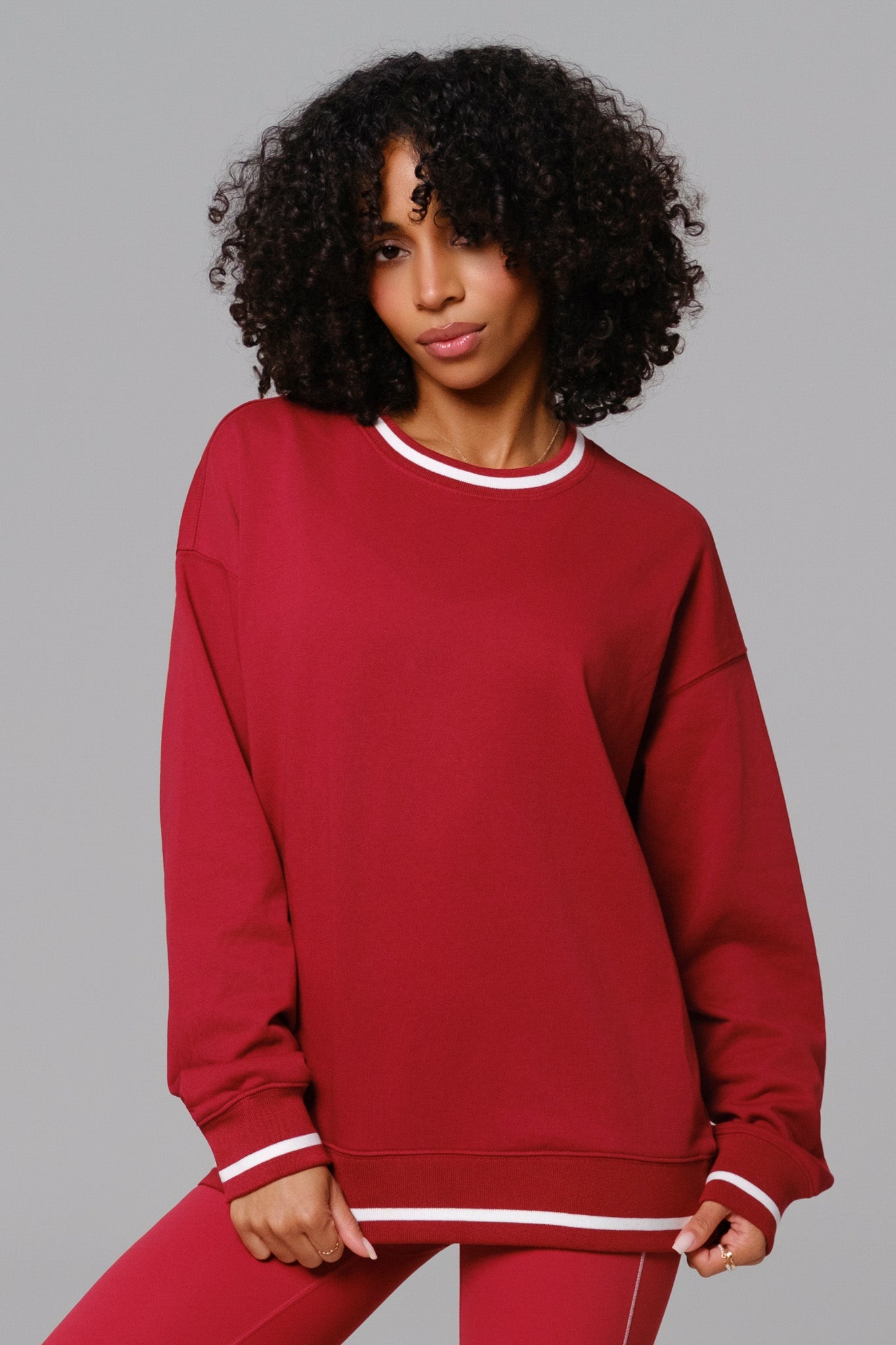 Woman wearing a cherry red sweatshirt and leggings