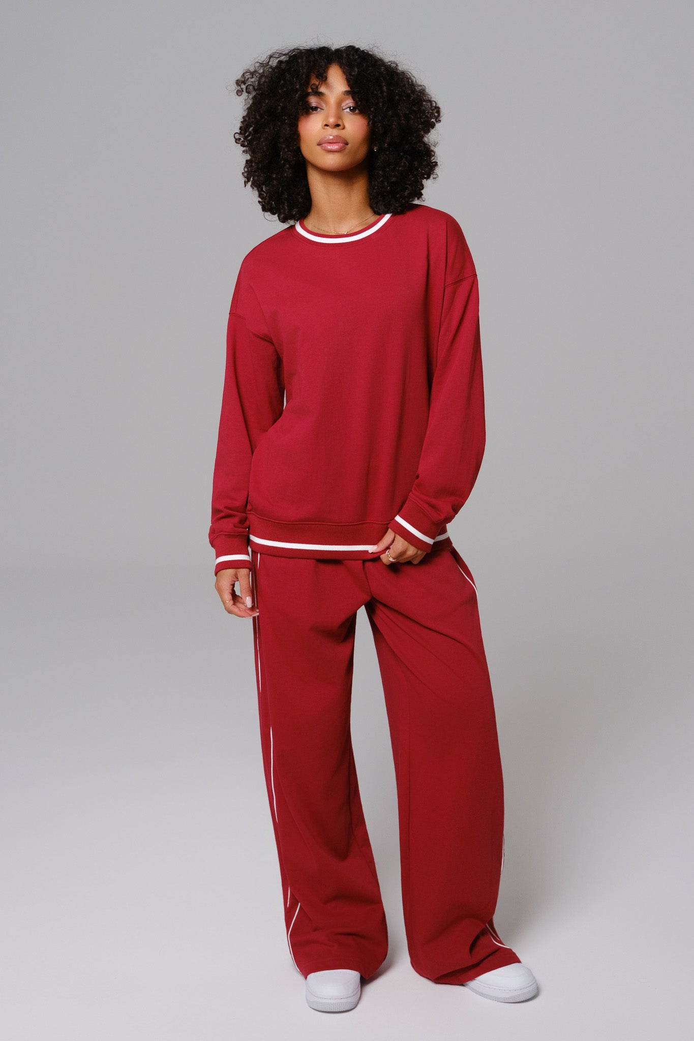 Woman wearing a cherry red casual sweater and matching sweatpants set