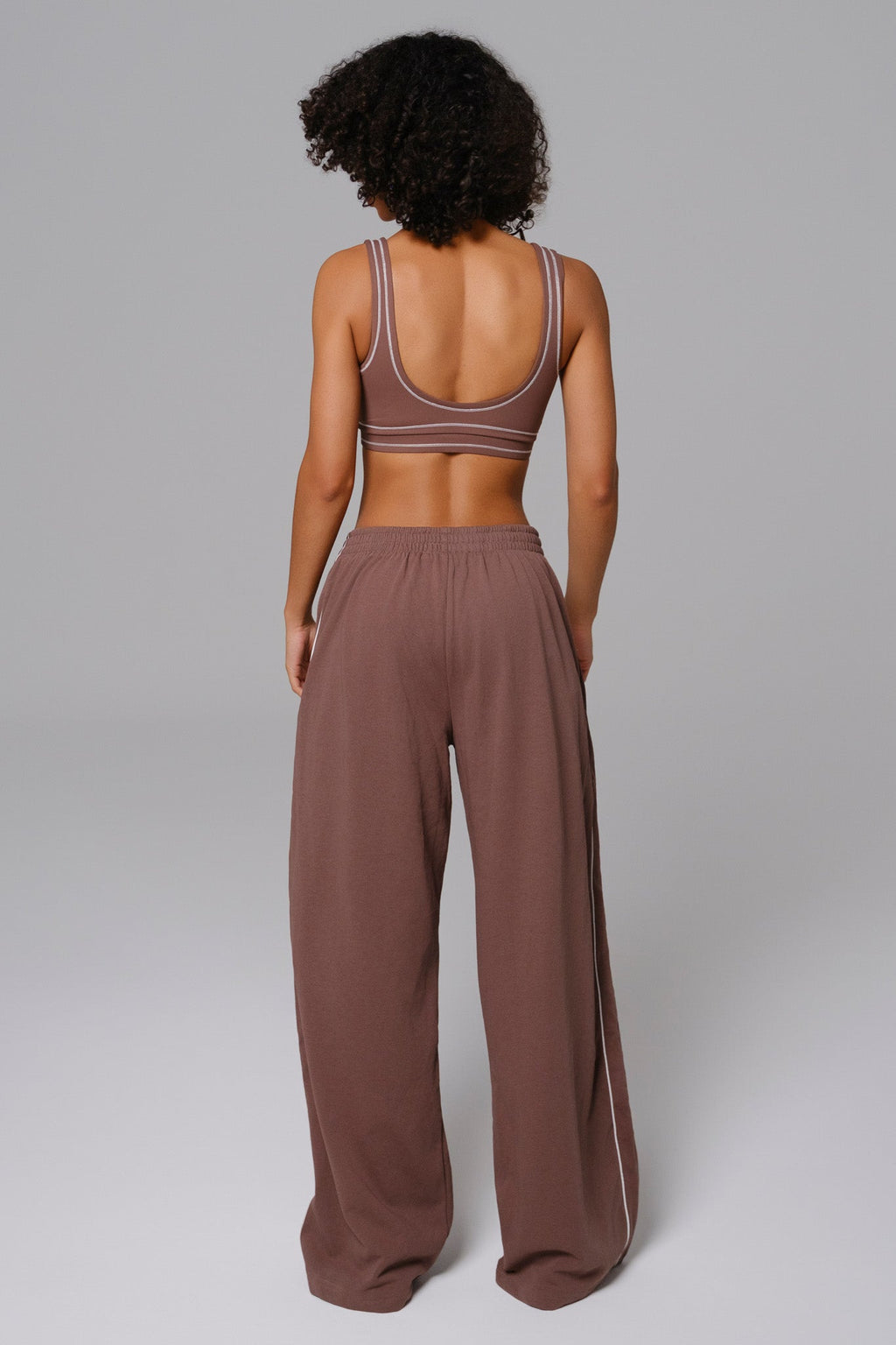 Woman wearing a brown mocha sports bra and wide-leg sweatpants 
