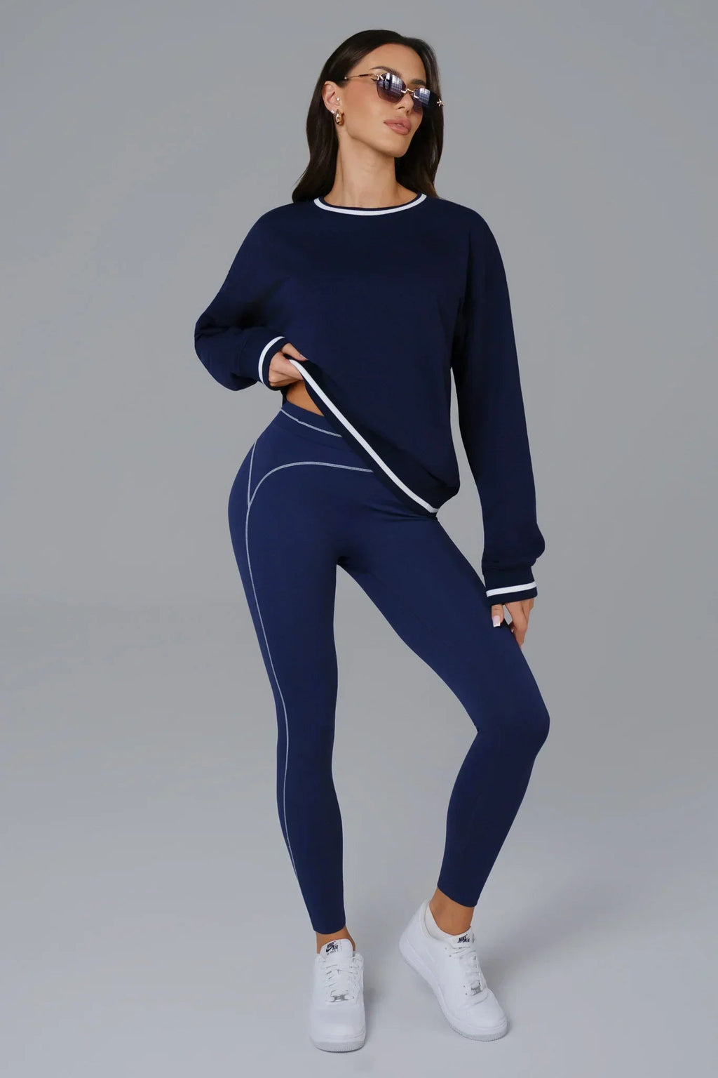 Woman wearing a navy blue outfit with white accents 