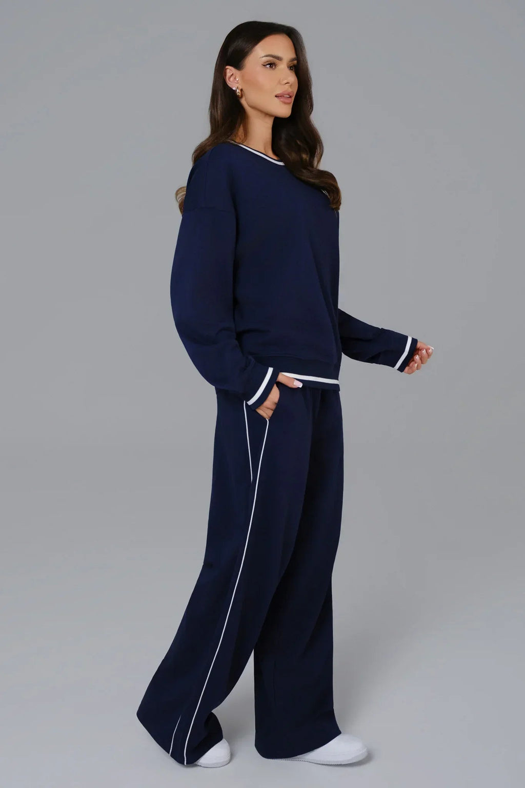 Woman wearing a navy blue outfit with white piping 