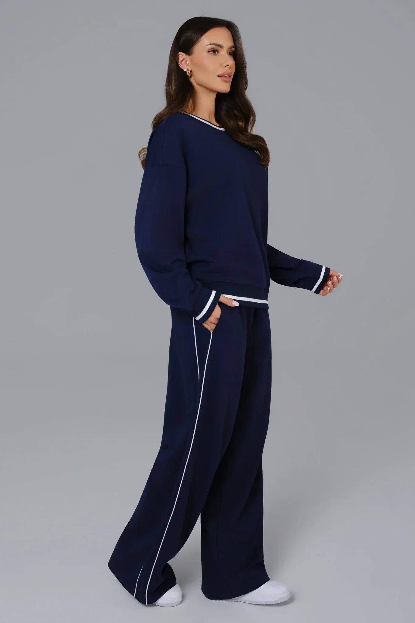 Woman wearing a navy blue outfit with white piping 