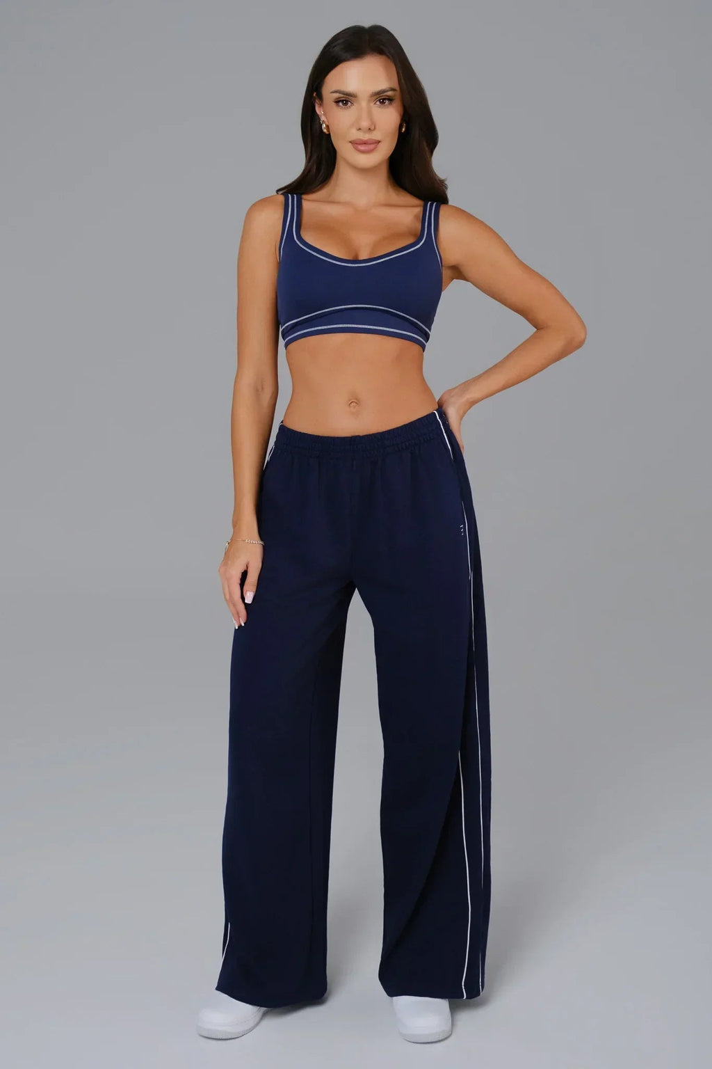 Woman wearing a navy blue matching sports bra and wide-leg pants 