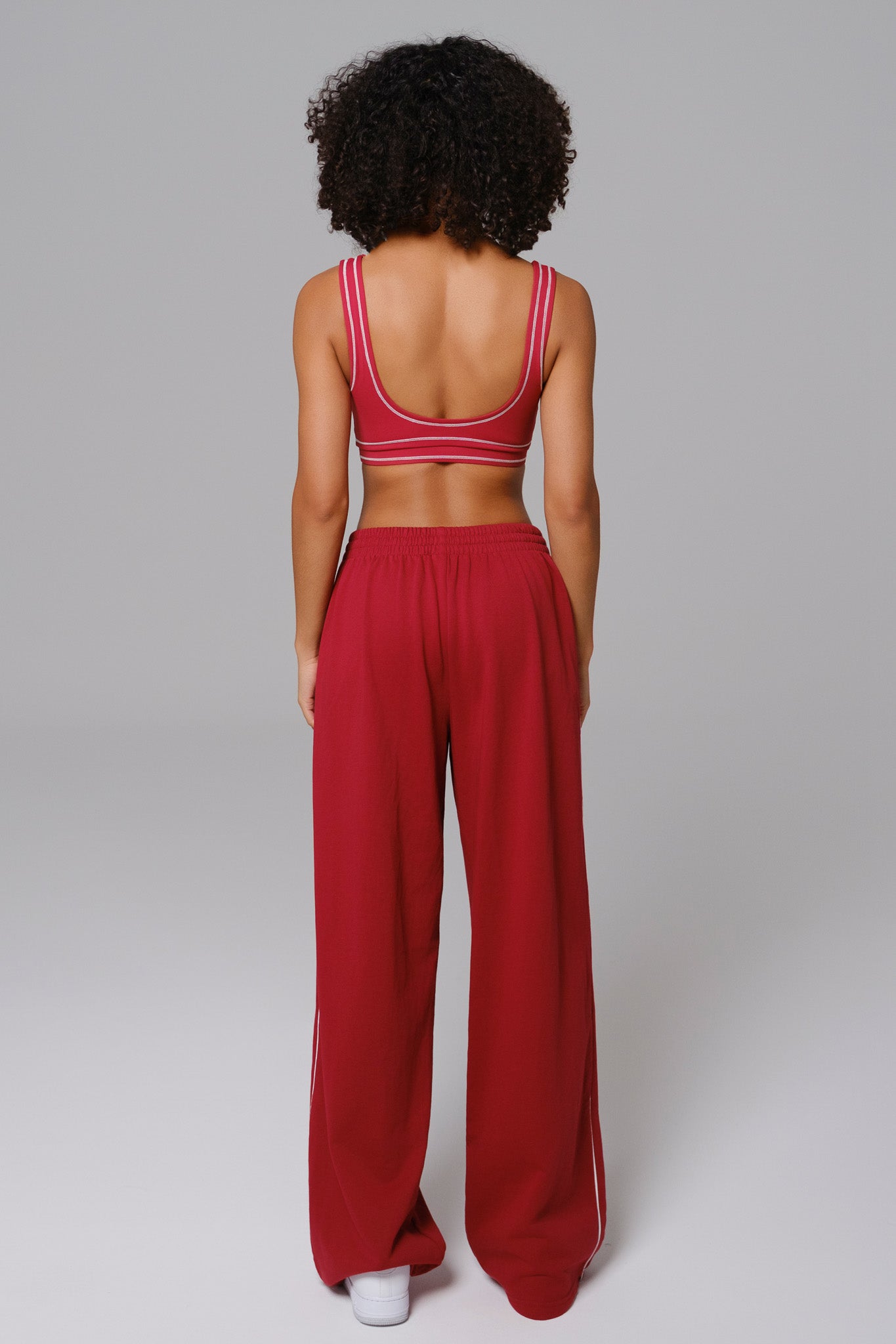 Person wearing a cherry red sports bra and wide-leg sweatpants 