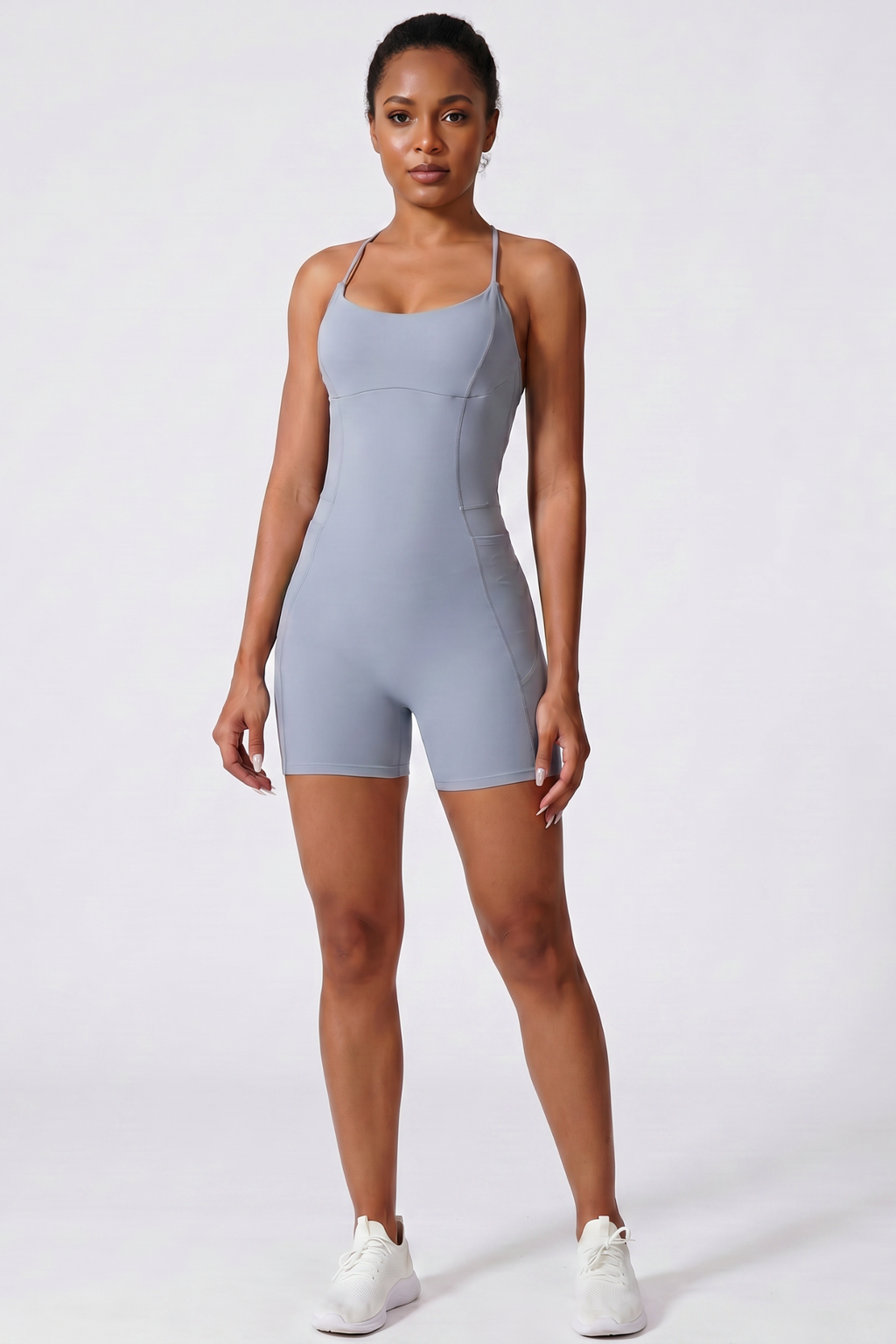 Woman wearing a haze blue bodysuit on a white background