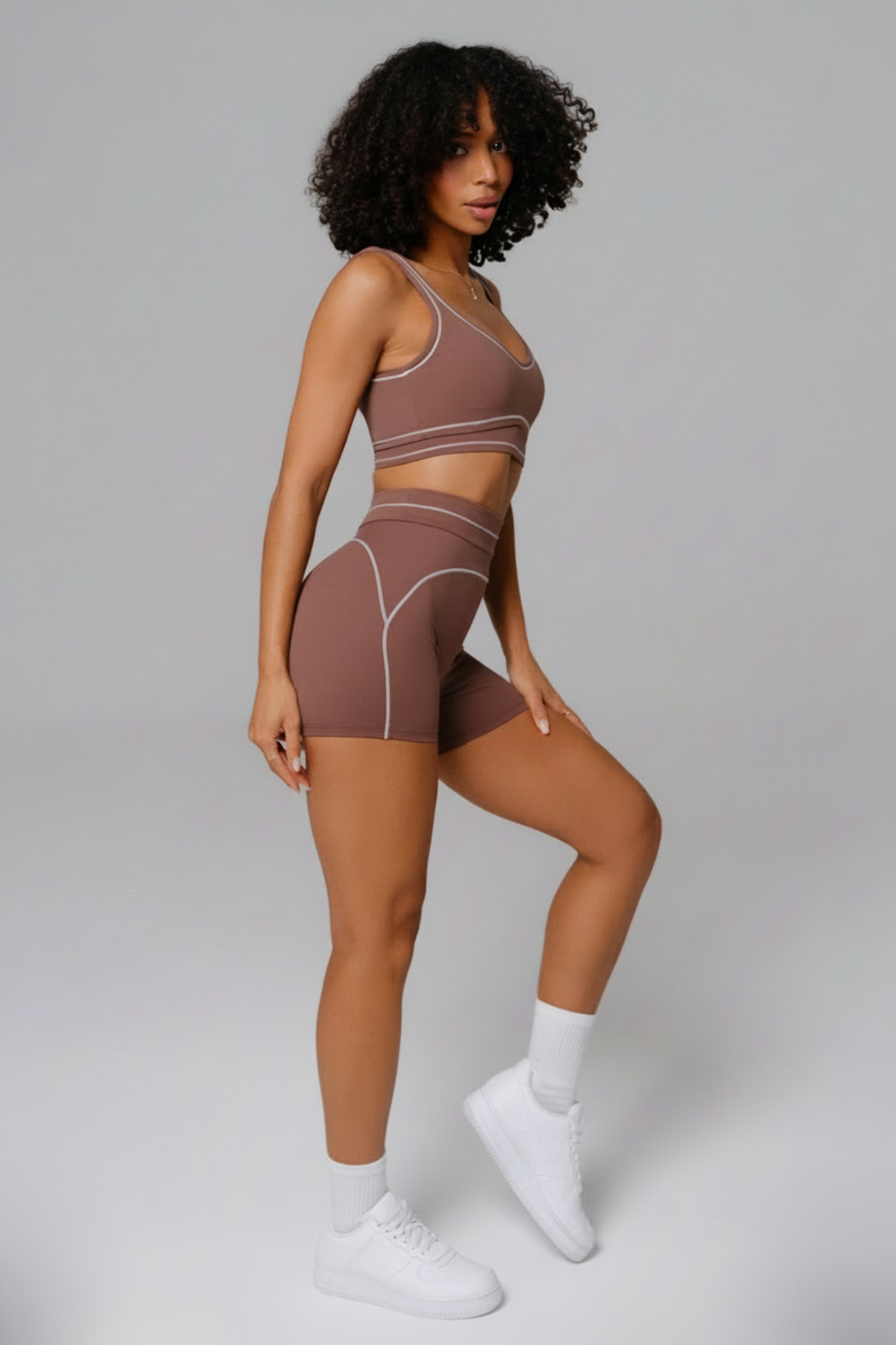 Woman wearing a mocha brown sports bra and shorts set 