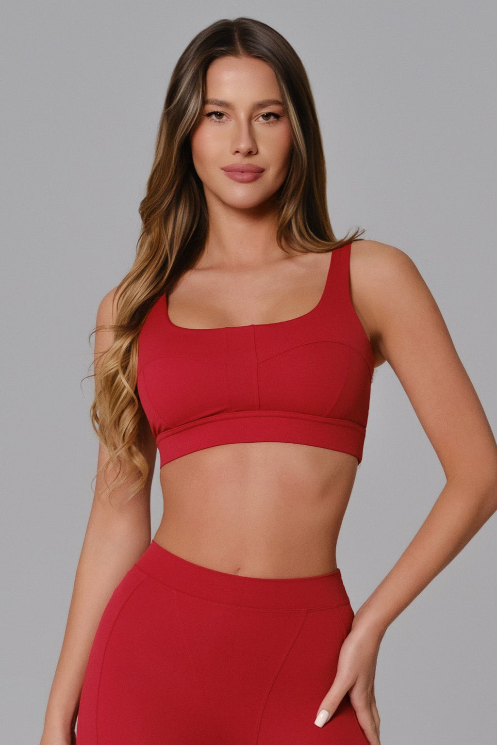 Woman wearing a red sports bra and leggings 