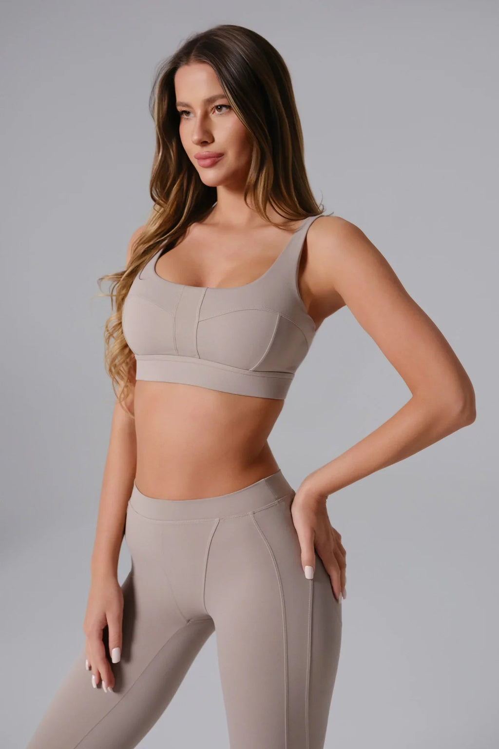 Woman wearing a Ash Taupe sports bra and leggings 