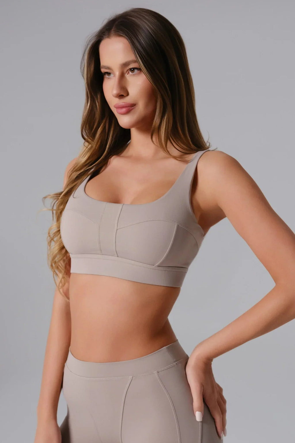 Woman wearing a Ash Taupe sports bra and leggings 