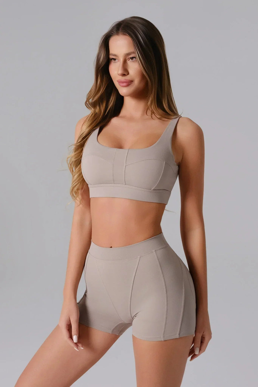 Woman wearing a Ash Taupe sports bra and shorts set 