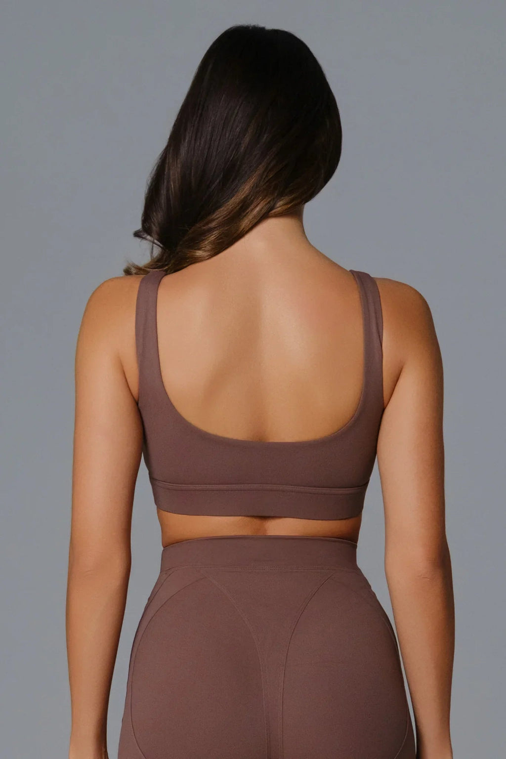 Woman wearing a Burnt Umber sports bra and leggings 