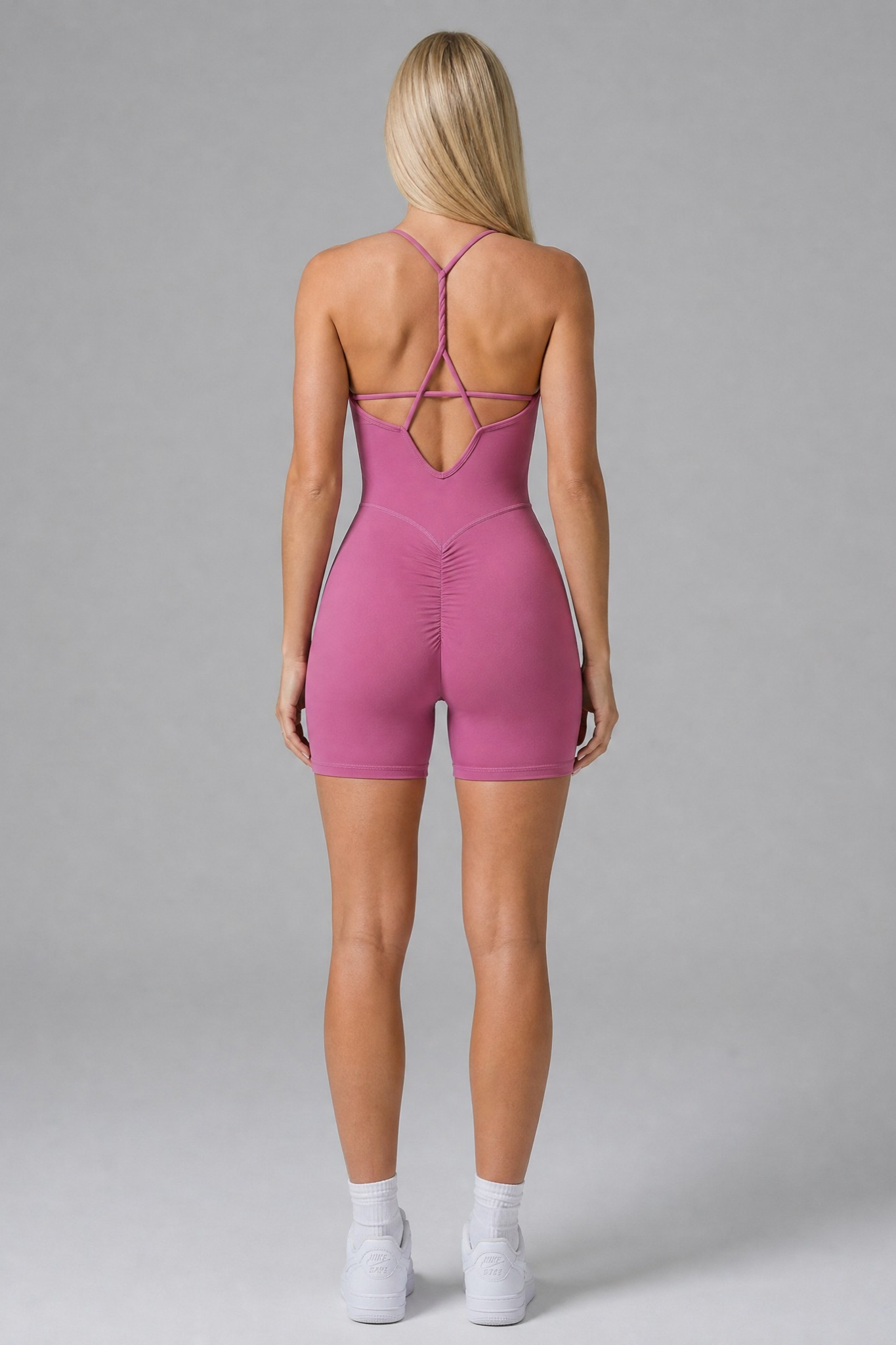 Person wearing a rose bodysuit on a gray background