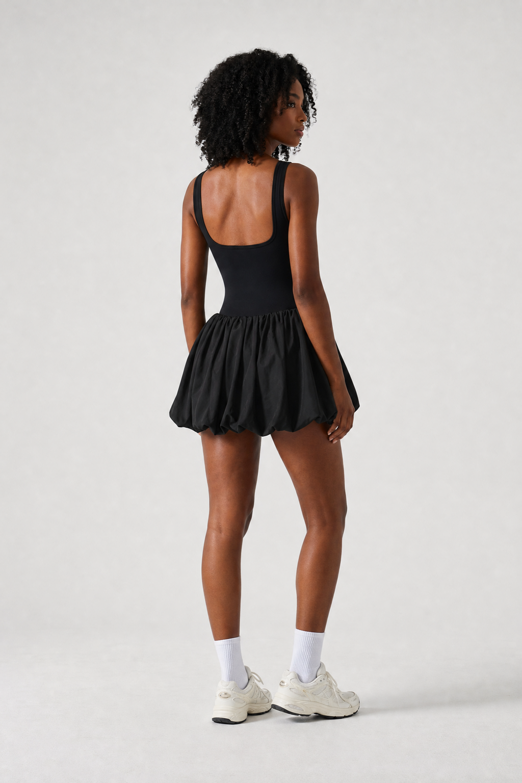 Woman in a Black Sporty Pleated Tennis Mini Dress with Shorts