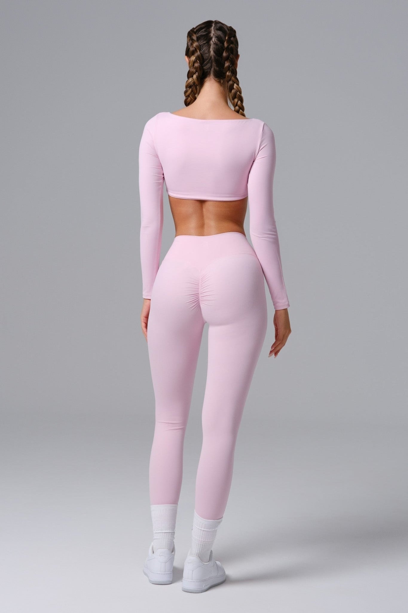 Person wearing a pink athletic outfit on a gray background