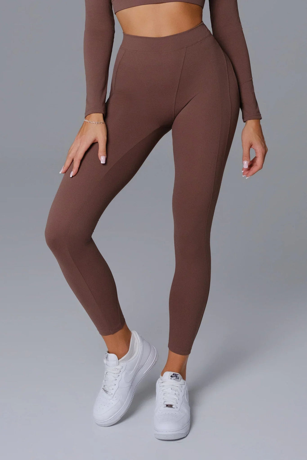 Woman wearing compressive curve enhancing burnt umber leggings 