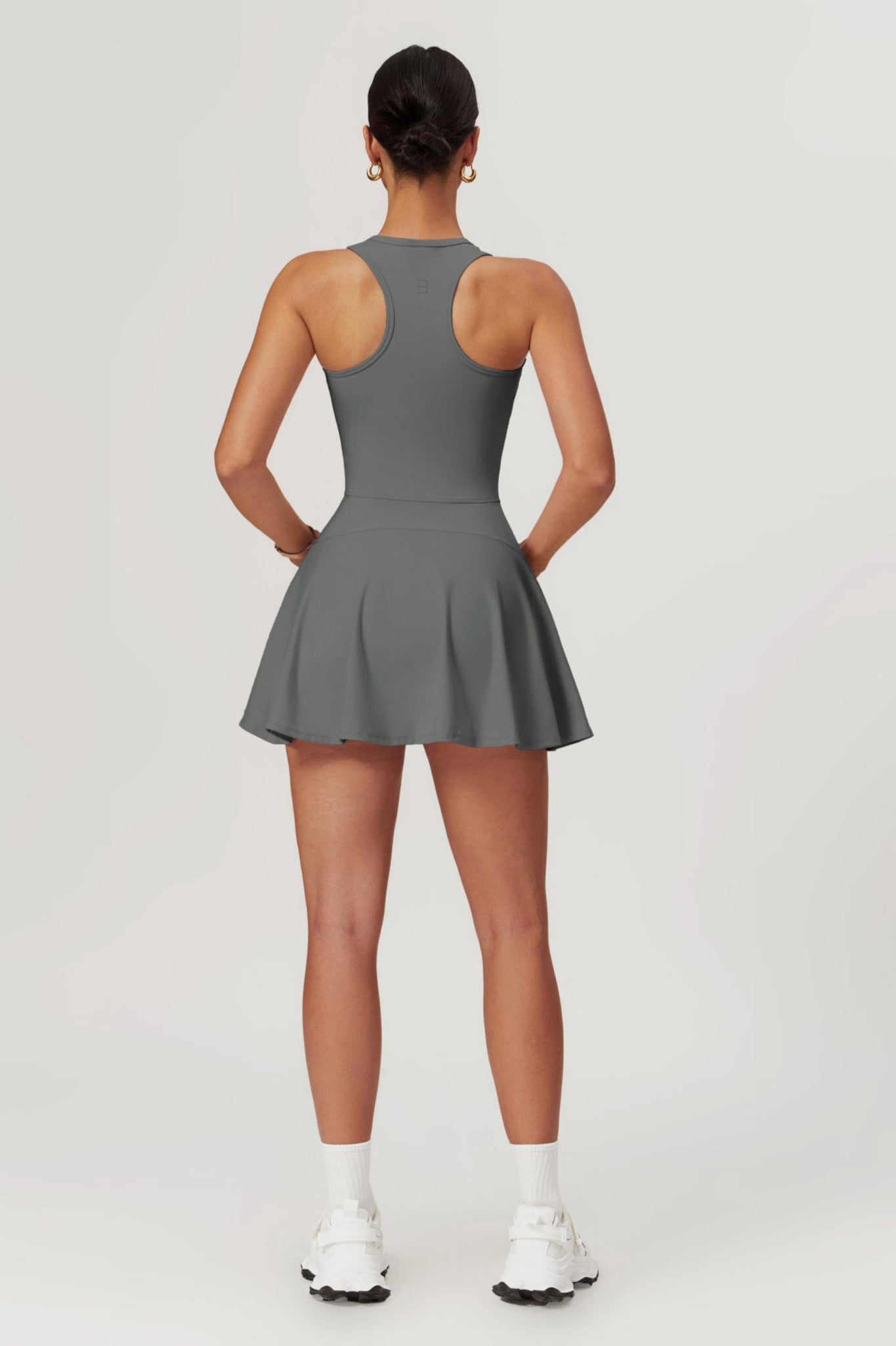 Person wearing a gray dress on a white background